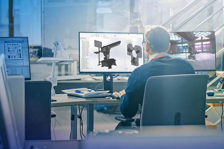 Man reviewing 3D model designs on screens